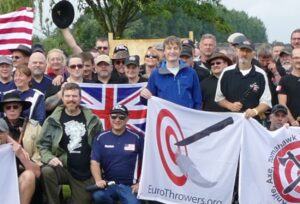 Group photo of people standing behind club banners at axe throwing tournament