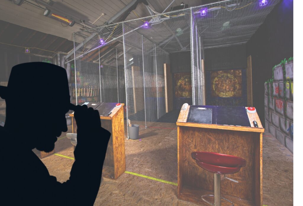 Interior of Eat Sleep Axe, Cheltenham with metal fenced axe throwing lanes behind wooden scoring podiums