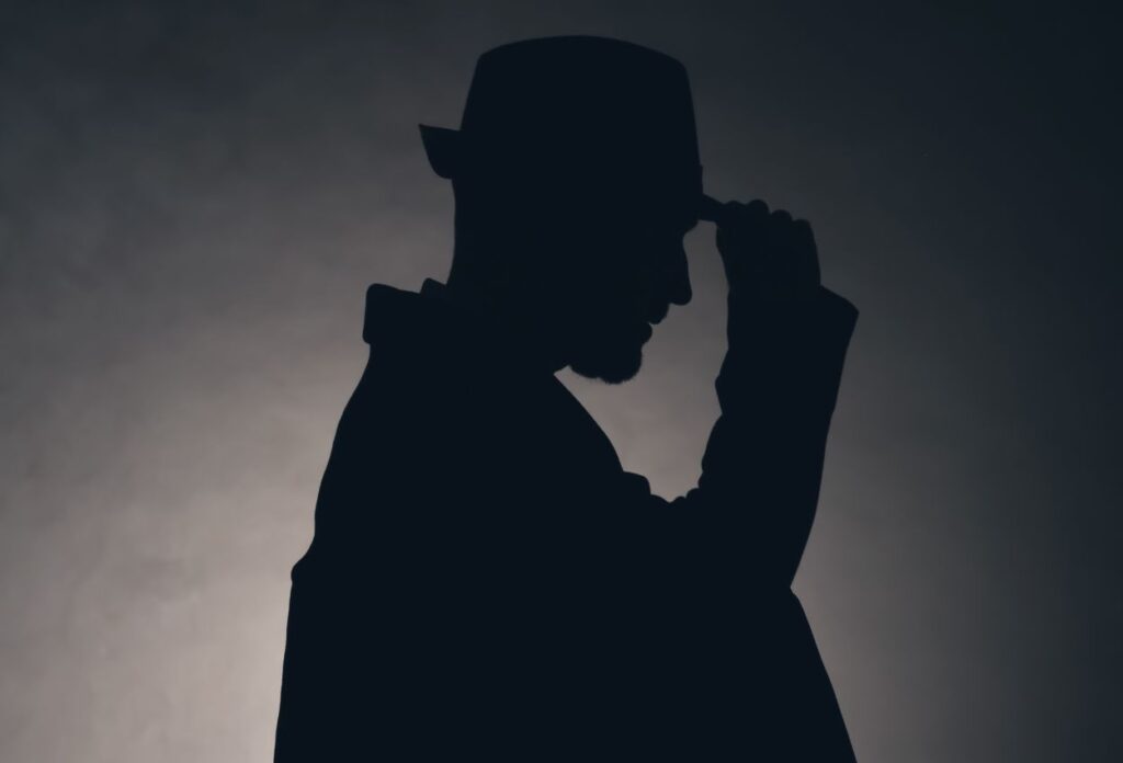 Silhouette of a man with trilby hat and briefcase under arm