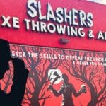 Outside of the Slashers Axe Throwing venue with a poster showing a forest and horror style axe wielding man