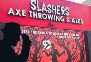 Outside of the Slashers Axe Throwing venue with a poster showing a forest and horror style axe wielding man