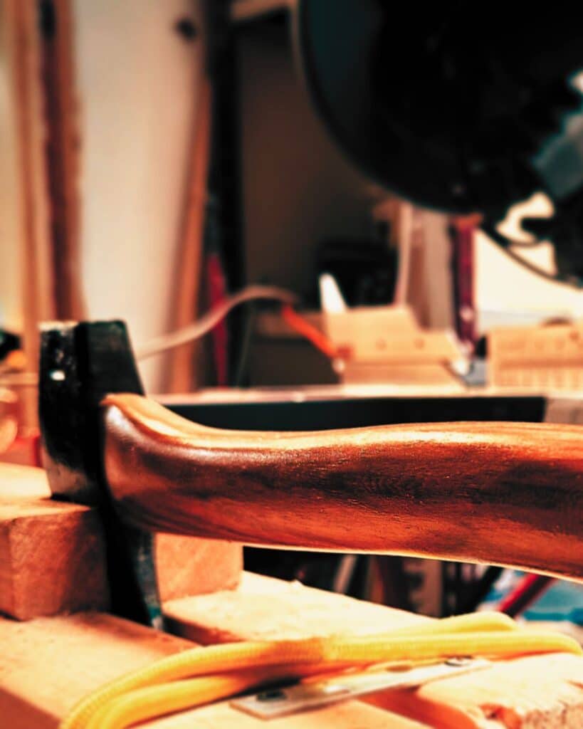 An axe held in a vice with the haft to the camera