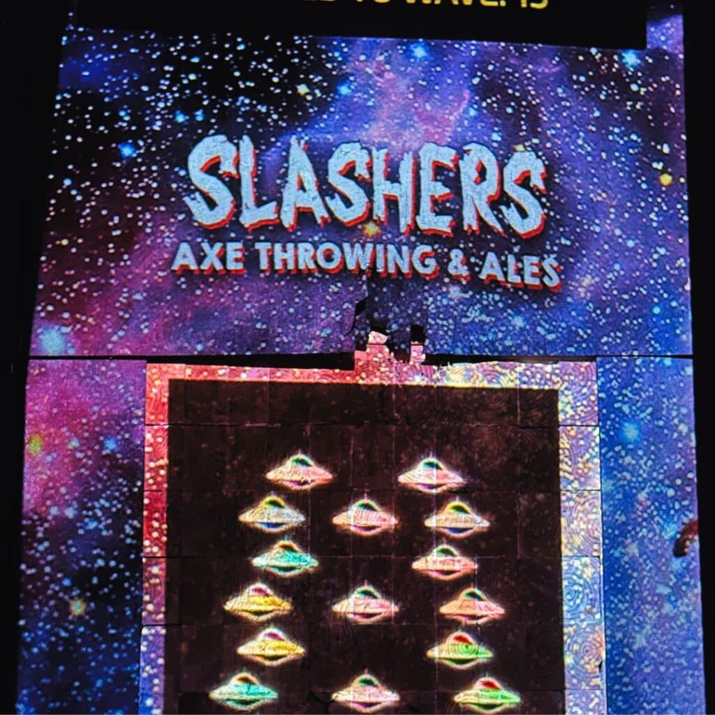 Axe throwing target with arcade game style alien spaceships on the boards