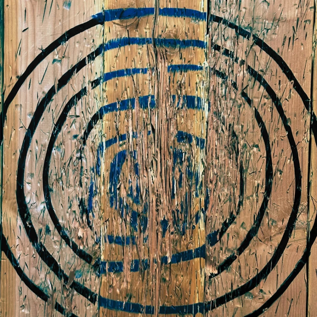 An axe throwing board with a roughly drawn target on it at the entrepreneurial Smash Kingdom venue