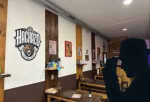 Axe inspector silhouette in front of the inside of the Valencia axe throwing bar